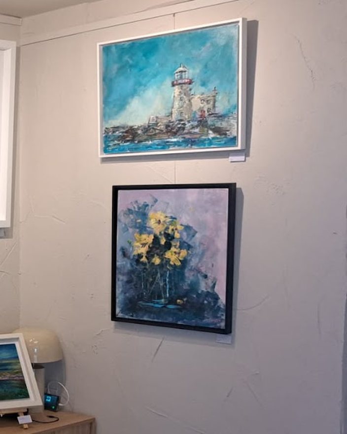 Framed paintings hung on the gallery's side wall